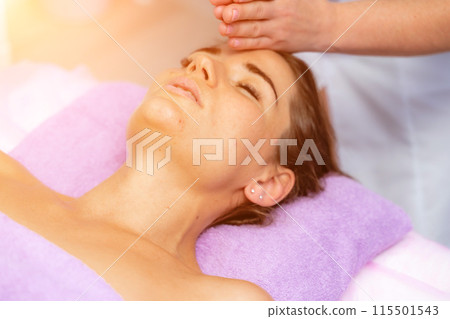 Relaxing massage. European woman getting facial massage in spa salon, side view 115501543