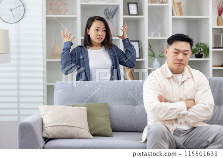 Young couple having an argument in their living room, showcasing stress and relationship issues. Young couple having an argument in their living room, showcasing stress and relationship issues. 115501631