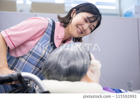 照顧坐在輪椅上的老人的形象：微笑的護理人員的特寫 115502091