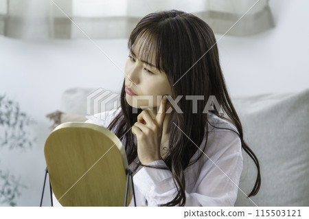 年輕女子照鏡子檢查皮膚狀況 115503121