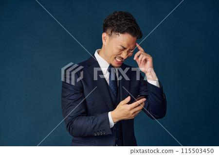 Businessman thinking with a smartphone 115503450