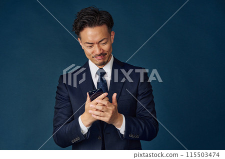 Businessman looking at a smartphone Businessman looking at a smartphone 115503474