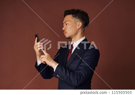 Businessman looking at a smartphone 115503503