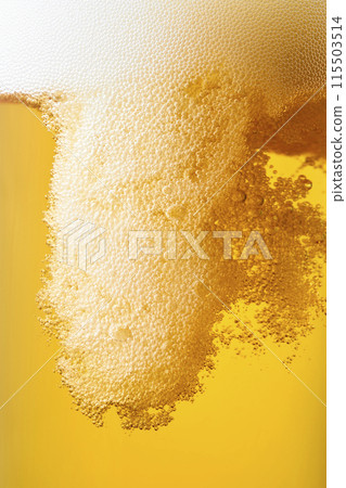 Draft beer poured into a glass, close-up 115503514