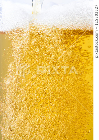 Draft beer poured into a glass, close-up 115503527