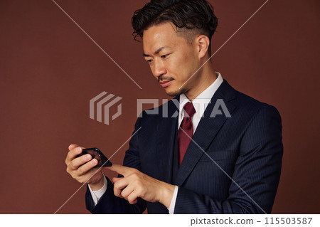 Businessman watching the game on a smartphone 115503587