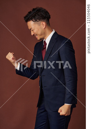  Businessman who plays guts pose 115504046