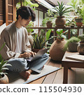 Man Using Laptop on Outdoor Patio With Plants 115504930