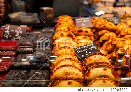 An empanada is a type of pastry baked or fried in Hispanic cultures. Mix set empanadas and berries on outdoors bazar. Closeup of baked snack empanada at market, popular Spanish street food An empanada is a type of pastry baked or fried in Hispanic cultures. Mix set empanadas and berries on outdoors bazar. Closeup of baked snack empanada at market, popular Spanish street food 115505211