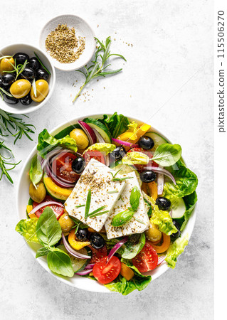 Fresh healthy vegetable Mediterranean food salad of Greek feta cheese, tomato, olives, pepper, lettuce and green basil leaves, top view Fresh healthy vegetable Mediterranean food salad of Greek feta cheese, tomato, olives, pepper, lettuce and green basil leaves, top view 115506270