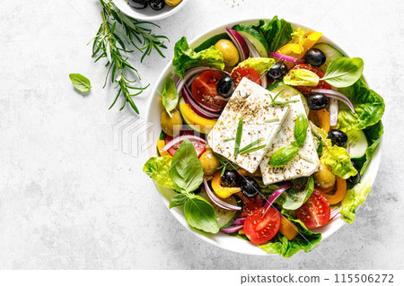 Fresh healthy vegetable Mediterranean food salad of Greek feta cheese, tomato, olives, pepper, lettuce and green basil leaves, top view Fresh healthy vegetable Mediterranean food salad of Greek feta cheese, tomato, olives, pepper, lettuce and green basil leaves, top view 115506272