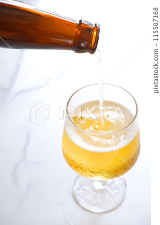 將冰鎮啤酒倒入玻璃杯中 將冰鎮啤酒倒入玻璃杯中 115507168