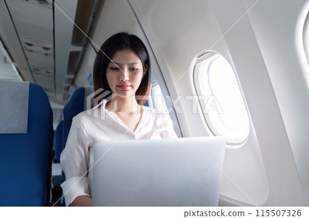 Businesswoman Working on Laptop During Airplane Travel, Professional Woman in Modern Air Travel Setting, Corporate Travel, Business Trip, In flight Productivity, Efficient Business Travel Businesswoman Working on Laptop During Airplane Travel, Professional Woman in Modern Air Travel Setting, Corporate Travel, Business Trip, In flight Productivity, Efficient Business Travel 115507326