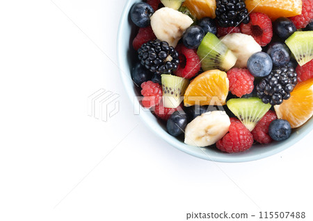 Fruit salad in a blue bowl isolated on white background. 115507488