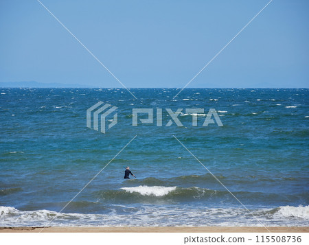 A man playing SUP board on the beach in summer 115508736