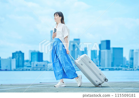Young woman walking with suitcase 115509181