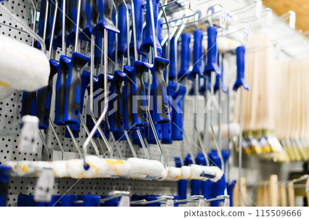 A store display of paint brushes and rollers. The display is organized by color and size. A store display of paint brushes and rollers. The display is organized by color and size. 115509666