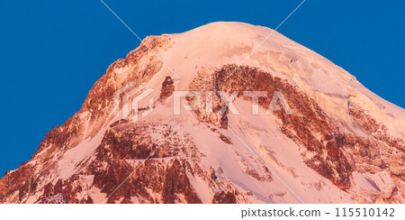 Georgia. Mount Kazbek Covered Snow In Winter Sunrise. Morning Dawn Colored Top Of Mountain In Pink-orange Colors. Awesome Winter Georgian Nature Landscape. Georgia. Mount Kazbek Covered Snow In Winter Sunrise. Morning Dawn Colored Top Of Mountain In Pink-orange Colors. Awesome Winter Georgian Nature Landscape. 115510142