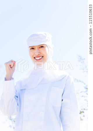 一位在食品工廠工作的年輕女子握拳 115510633