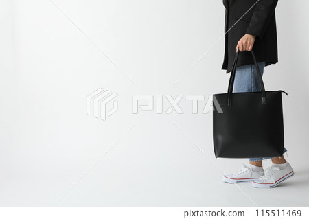 A woman holds a bag on a white background 115511469