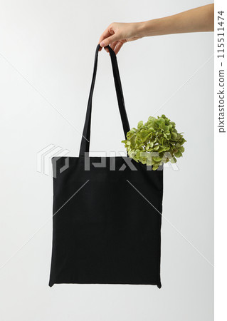 Black bag in hand on white background 115511474