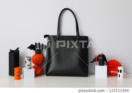 Black bag with Halloween decorations on a white background 115511494