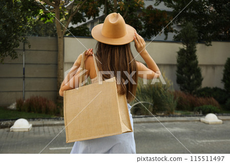 A woman in a hat and a bag on her shoulder A woman in a hat and a bag on her shoulder 115511497