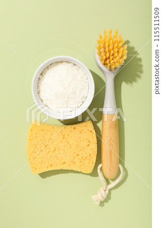 Brushes, sponge and soda in bowl on green background, top view 115511509