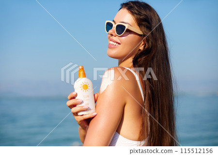 Beauty Woman applying sunscreen creme on tanned shoulder. Skincare. Body Sun protection 115512156