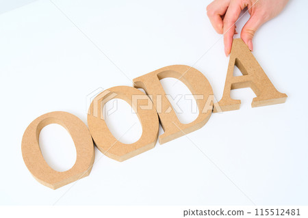 Wooden alphabet blocks arranged with the word "OODA" 115512481