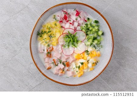 Traditional Russian summer cold soup okroshka with kefir in ceramic bowl on rustic wooden table 115512931
