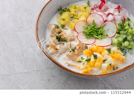 Okroshka smoked chicken breast - Russian cold soup with vegetables on white wooden background. Selective focus 115512944
