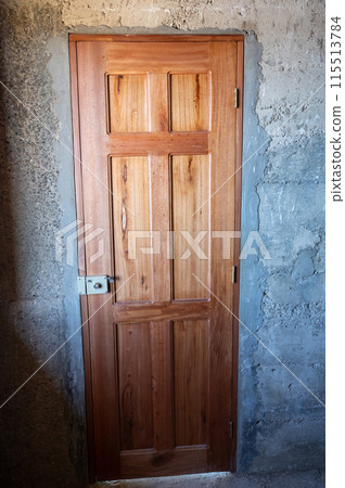 Wooden door in concrete wall Wooden door in concrete wall 115513784