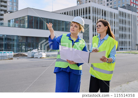 Two confident women talking working on construction of residential office building Two confident women talking working on construction of residential office building 115514358
