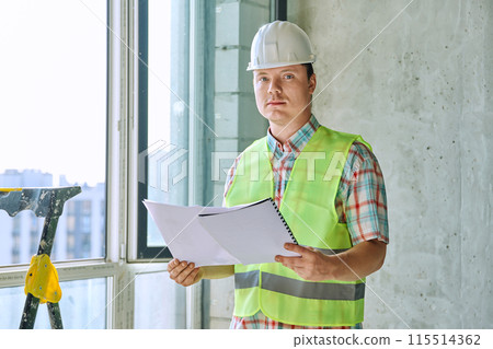 Portrait of male industrial worker in vest helmet with engineering documents 115514362