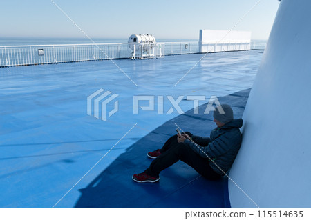 Traveler with smartphone on deck of a cruise ship Traveler with smartphone on deck of a cruise ship 115514635