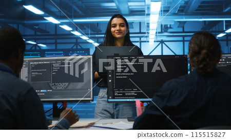 Portrait of smiling Indian manager in server room managing team of engineers looking for equipment misconfigurations. Happy team leader coordinating employees checking data center bottlenecks 115515827