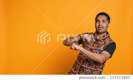 Smiling person having fun, dancing on rhythm, enjoying relaxation time. Jolly indian man goofing around, entertaining himself doing funky movements, isolated over studio background, camera B 115515893