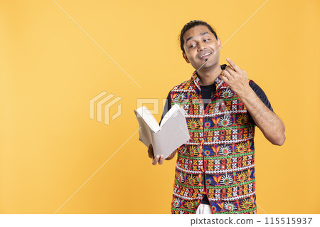 Indian man reading book aloud, narrating story for audience. Person enjoying literature novel, reciting from pages, entertaining spectators, isolated over studio background Indian man reading book aloud, narrating story for audience. Person enjoying literature novel, reciting from pages, entertaining spectators, isolated over studio background 115515937