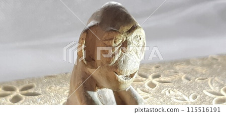 Netsuke carved from wood.A lonely sitting monkey looking into the distance. Netsuke carved from wood.A lonely sitting monkey looking into the distance. 115516191