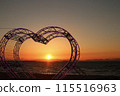 The sunset seen from a heart-shaped object 115516963