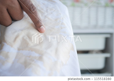 holding white color dirty shirt, finger showing making stain 115518160