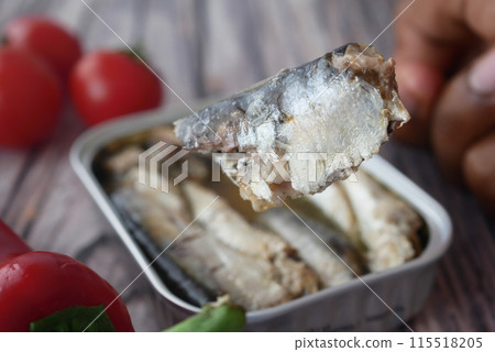 fork pick sardines from a open container fork pick sardines from a open container 115518205