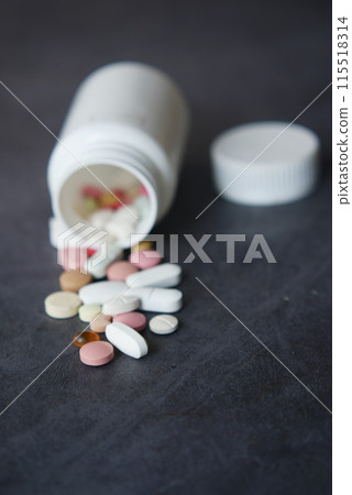 Pills Spilling Out of Medicine Bottle on Black background 115518314