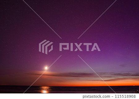 Stunning view of the aurora borealis with vibrant purple and orange hues, a bright moon reflecting on the calm Baltic Sea near Riga and Jurmala in Latvia. Stunning view of the aurora borealis with vibrant purple and orange hues, a bright moon reflecting on the calm Baltic Sea near Riga and Jurmala in Latvia. 115518908