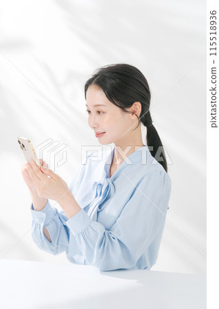 A woman using a smartphone A woman using a smartphone 115518936