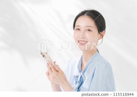 A woman using a smartphone A woman using a smartphone 115518944