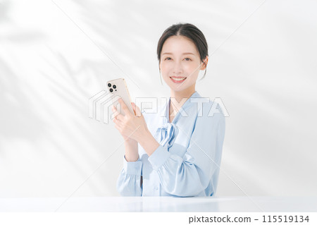 拿著智能手機的一名微笑的婦女 115519134