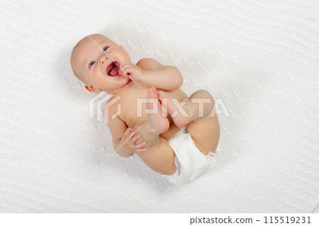 Little baby on white bed 115519231