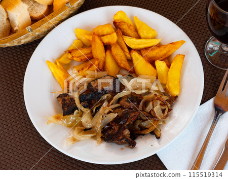 Fried liver served with onions and potatoes 115519314